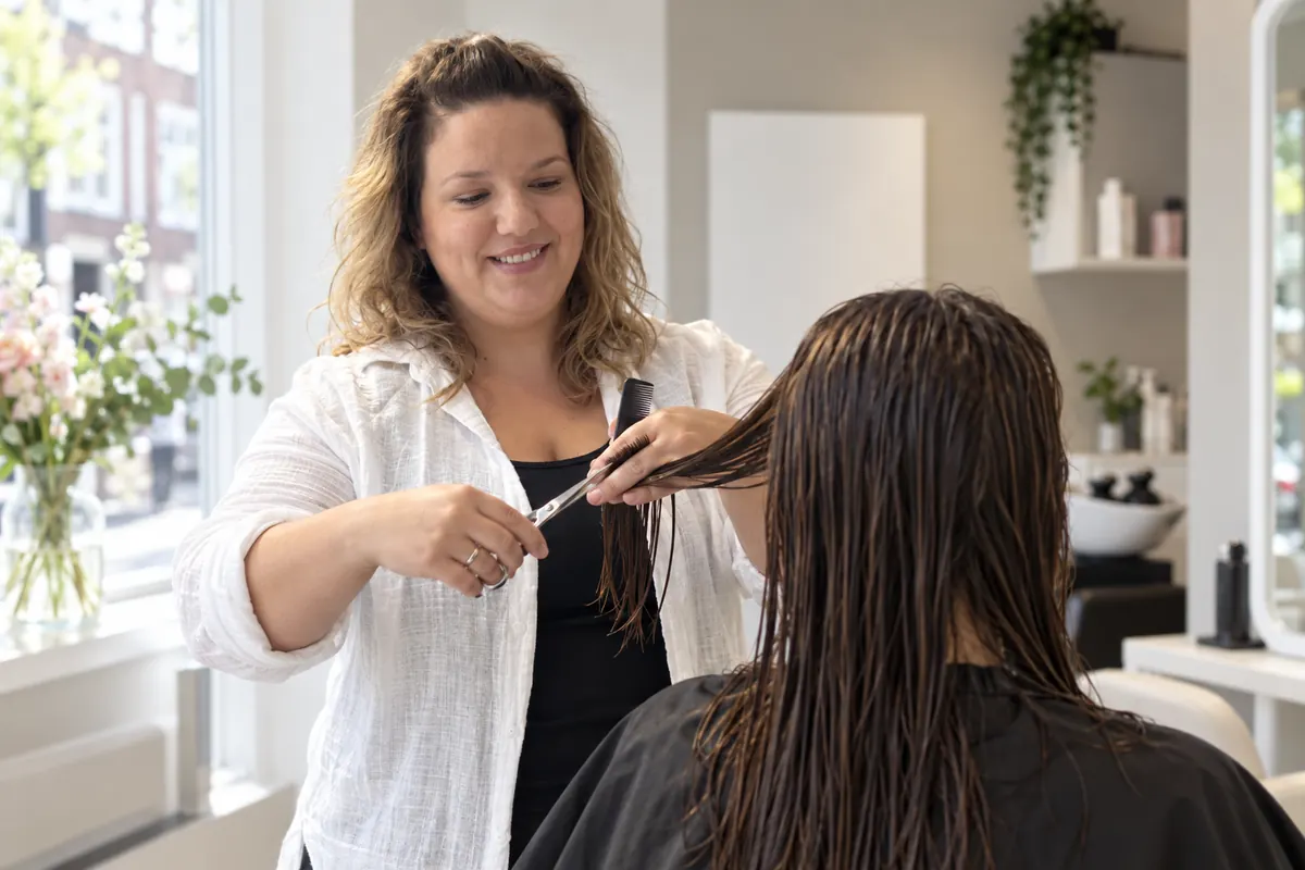 Eljana knipt het natte haar van een klant
